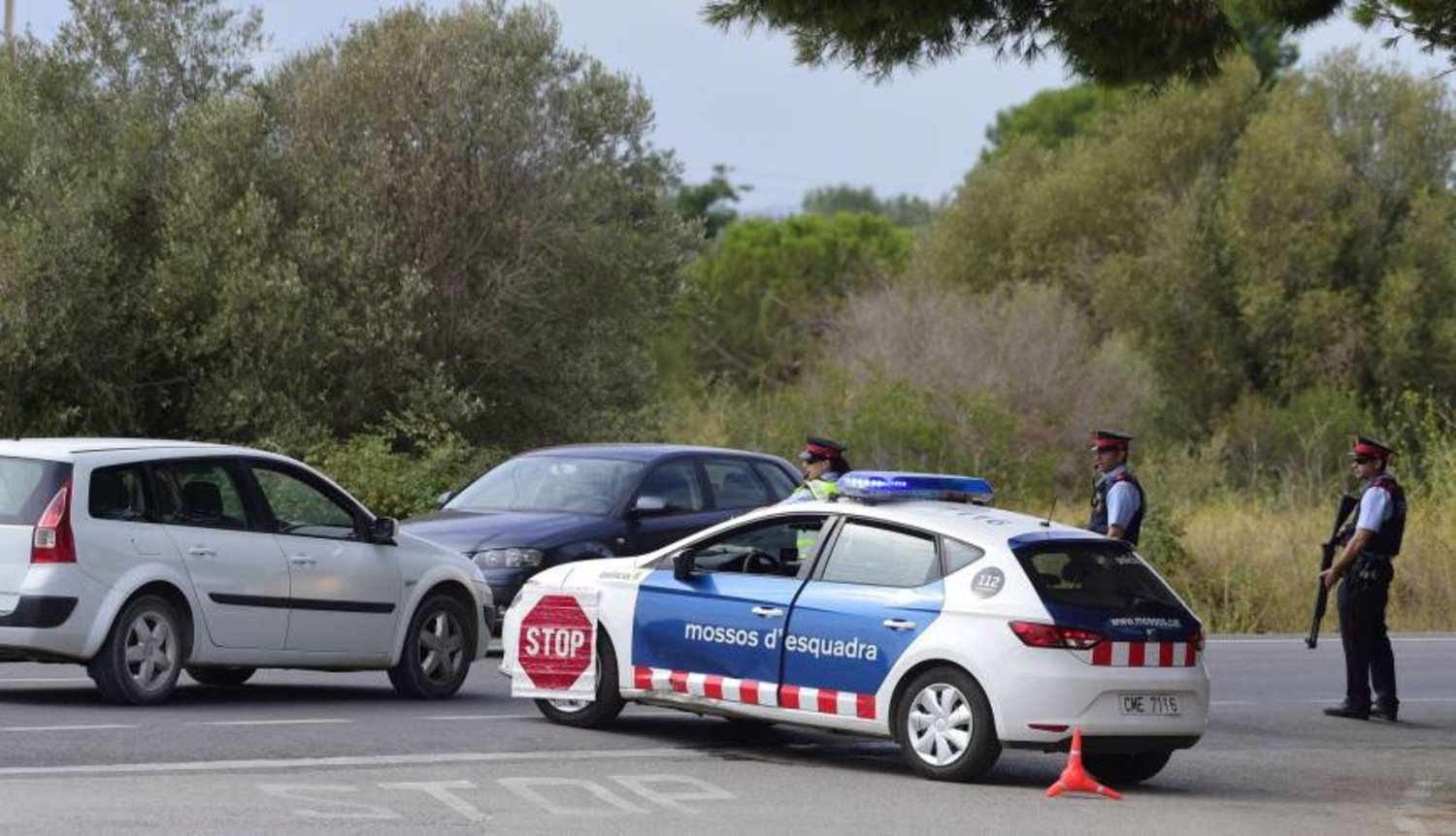 Police officers block a road near Alcanar, Spain, as part of an operation to find a suspect of Barcelona's attack. AFP