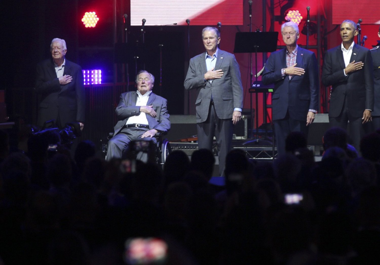 Ex-presidents Barack Obama, Bill Clinton, George W. Bush, George H.W. Bush and Jimmy Carter place their hands on their chest for the national anthem at the opening of a hurricanes relief concert in Texas. (AP)