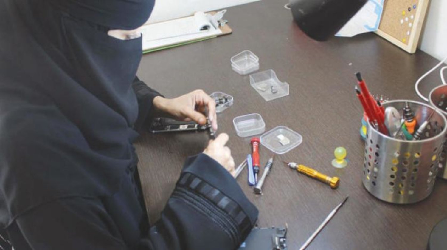 Saudi woman works in mobiles maintenance shop. Asharq Al-Awsat