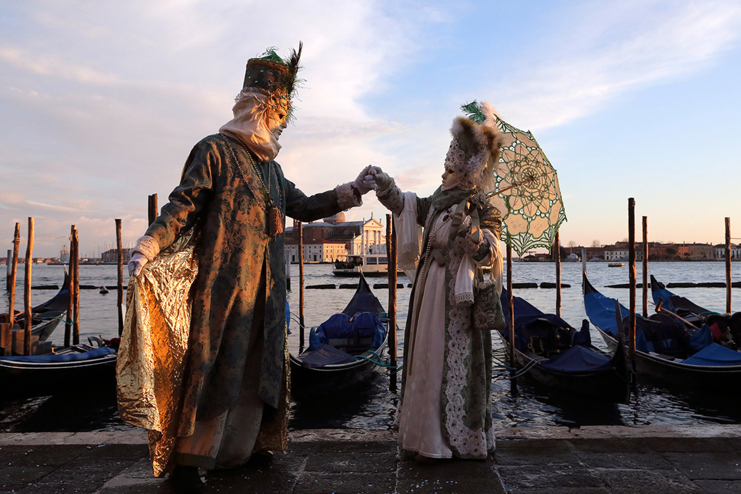 Masked revellers pose in front of gondolas in Venice Stefano Rellandini/Reuters