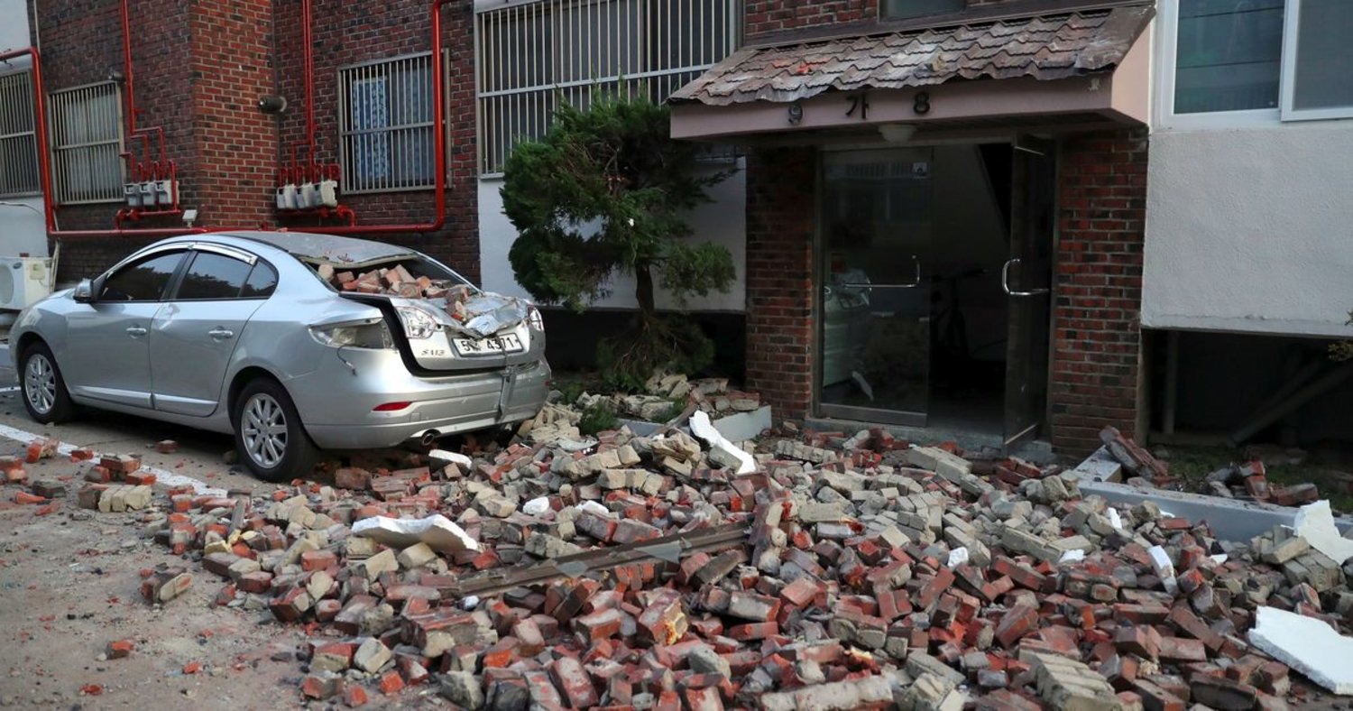 A car damaged by falling bricks after a 5.4-magnitude earthquake is seen in the southeastern port city of Pohang on November 15, 2017. YONHAP / AFP 