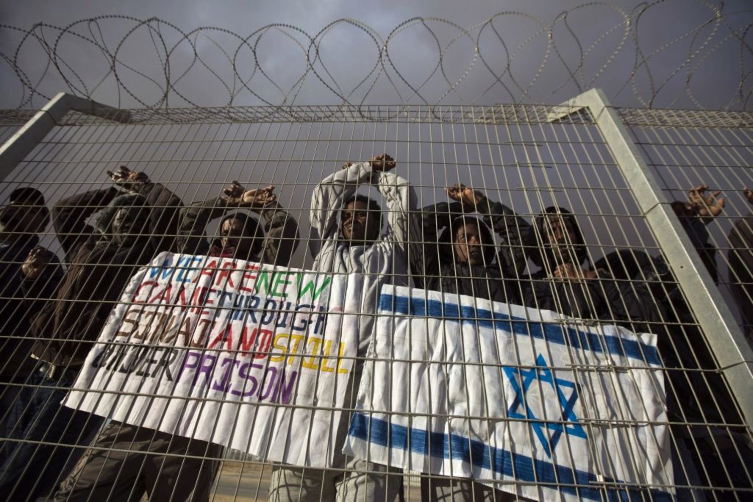 African migrants gesture behind a fence during a protest against Israel's detention policy towards them, at Holot, Israel's southern Negev desert detention center February 17, 2014.
REUTERS / AMIR COHEN