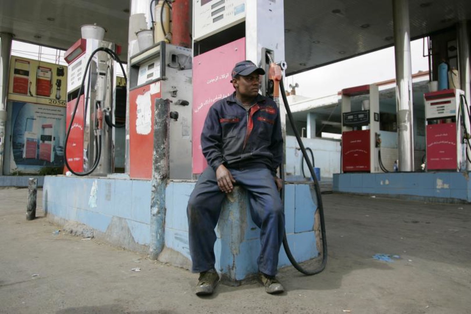 A worker sits in an empty petrol station in Sanaa. (Reuters)
