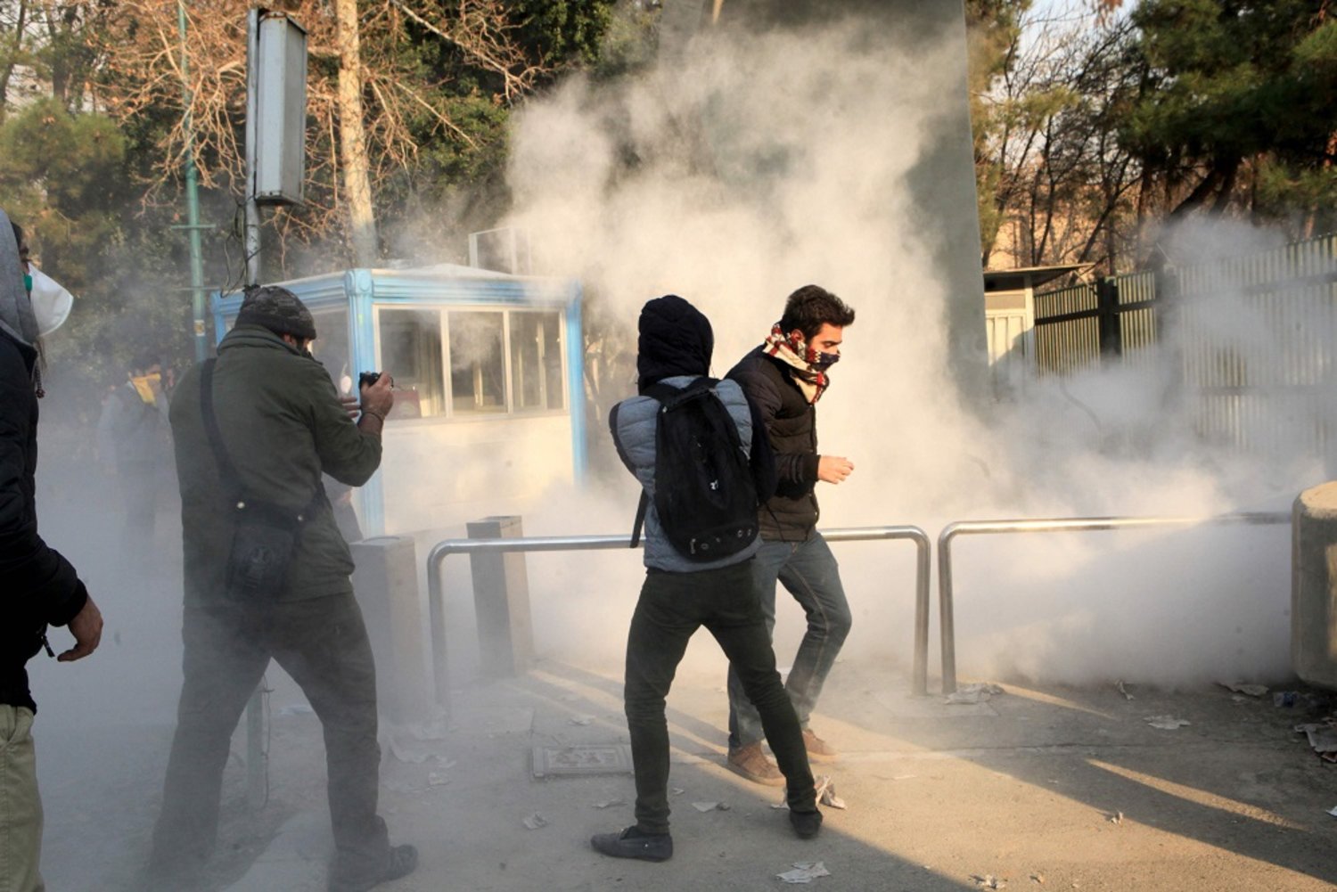 Iranian students run for cover after tear gas was fired during a demonstration at the University of Tehran on Saturday. (AFP)