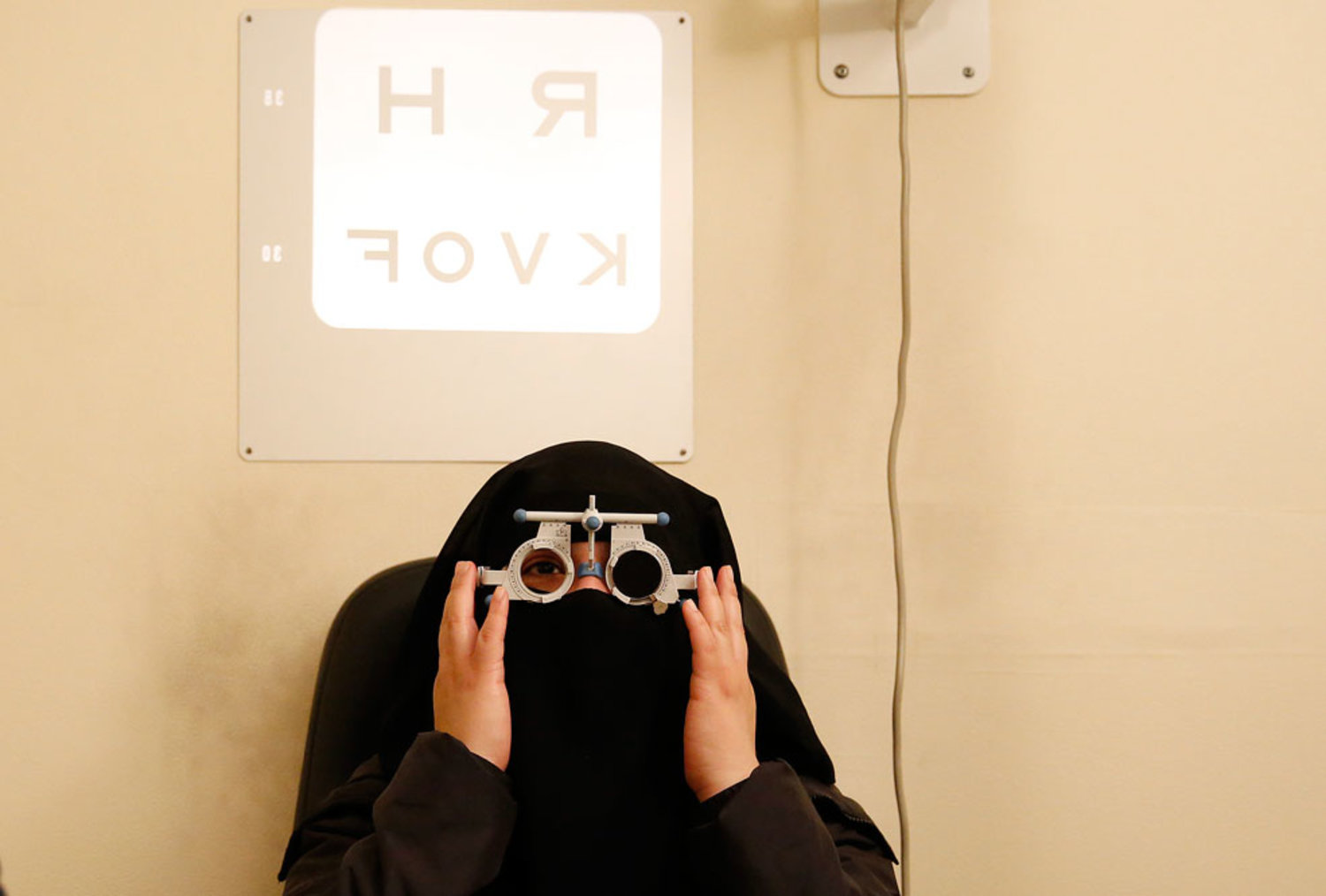 A woman takes an eye test in east London. REUTERS/Olivia Harris