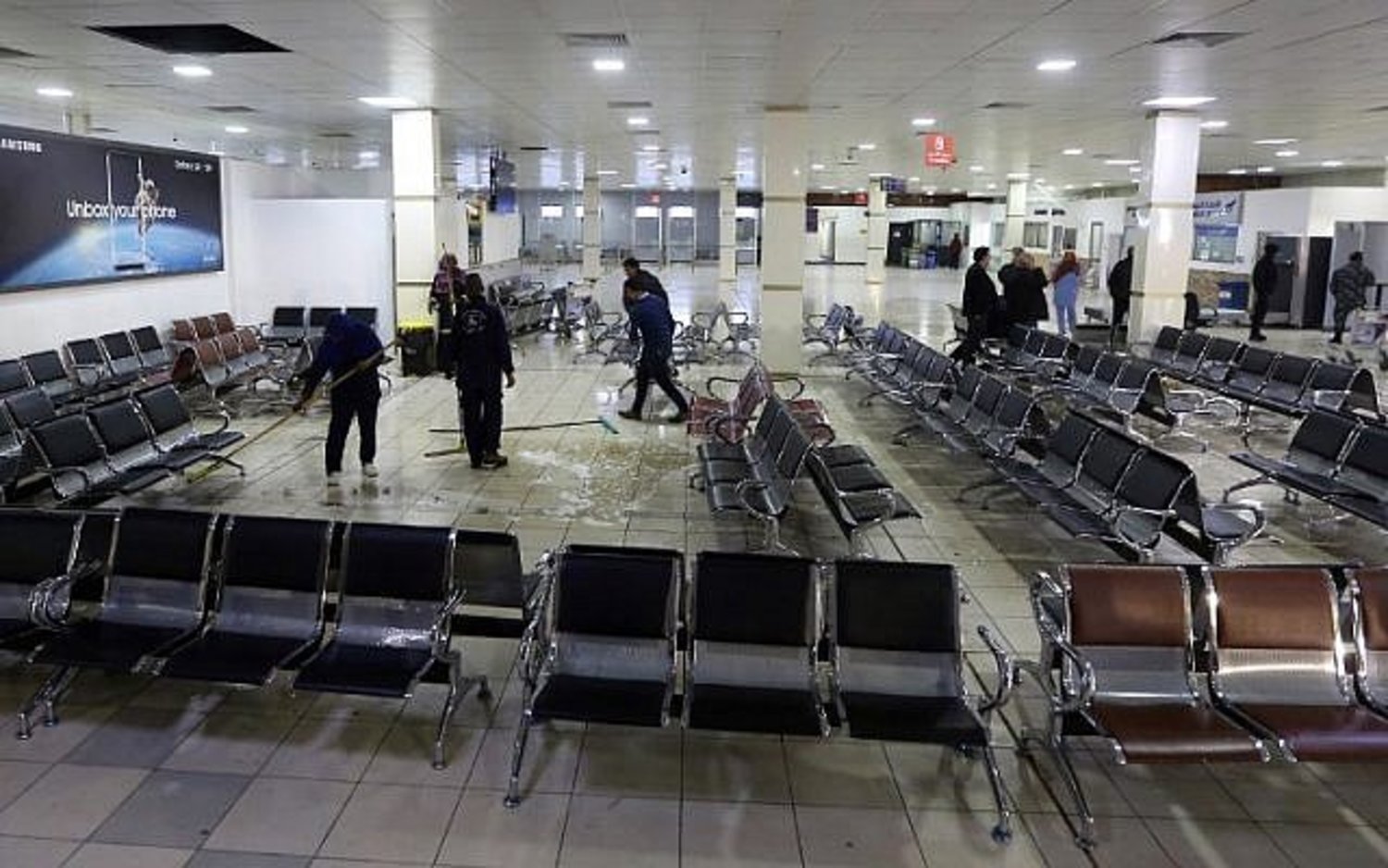 Libyans clean inside Mitiga airport the day after militiamen attacked it in an attempt to free colleagues held at a jail there, on the eastern outskirts of the Libyan capital Tripoli, on January 16, 2018. (AFP PHOTO / Mahmud TURKIA)
