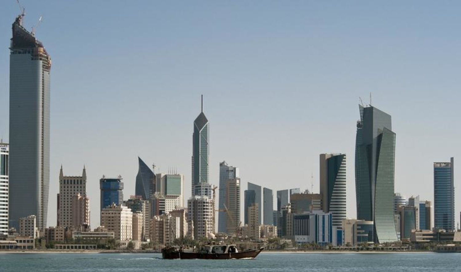 A fishing boat passes in front of the Kuwait City skyline September 11, 2010. REUTERS/Stephanie McGehee
