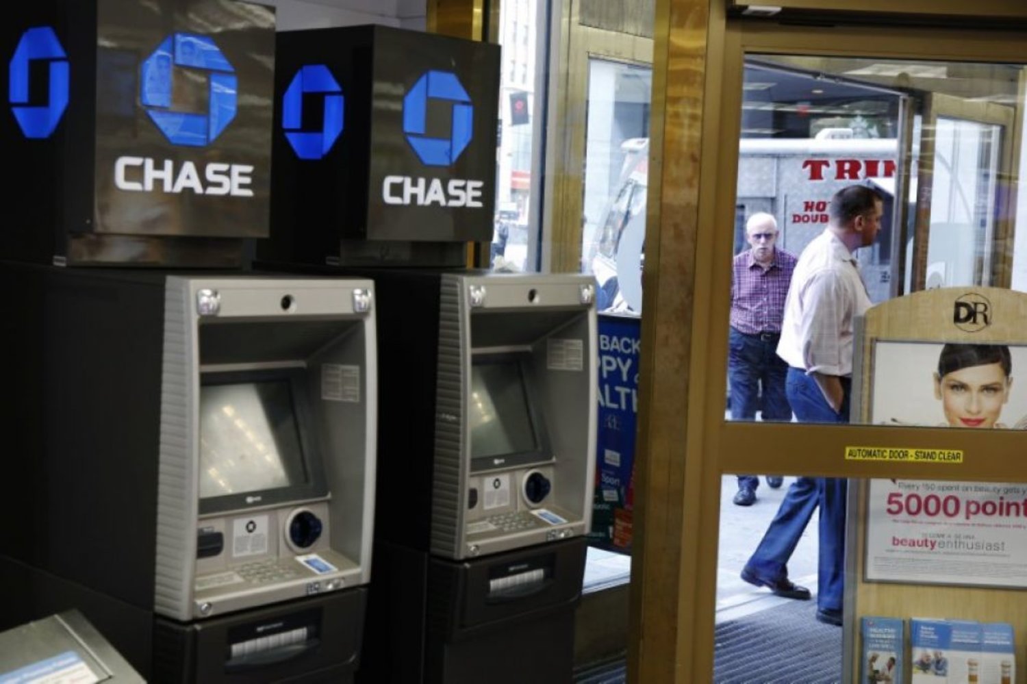 JPMorgan Chase ATMs stand near a door as customers walk past a Duane Reade store in New York. Photo: Reuters