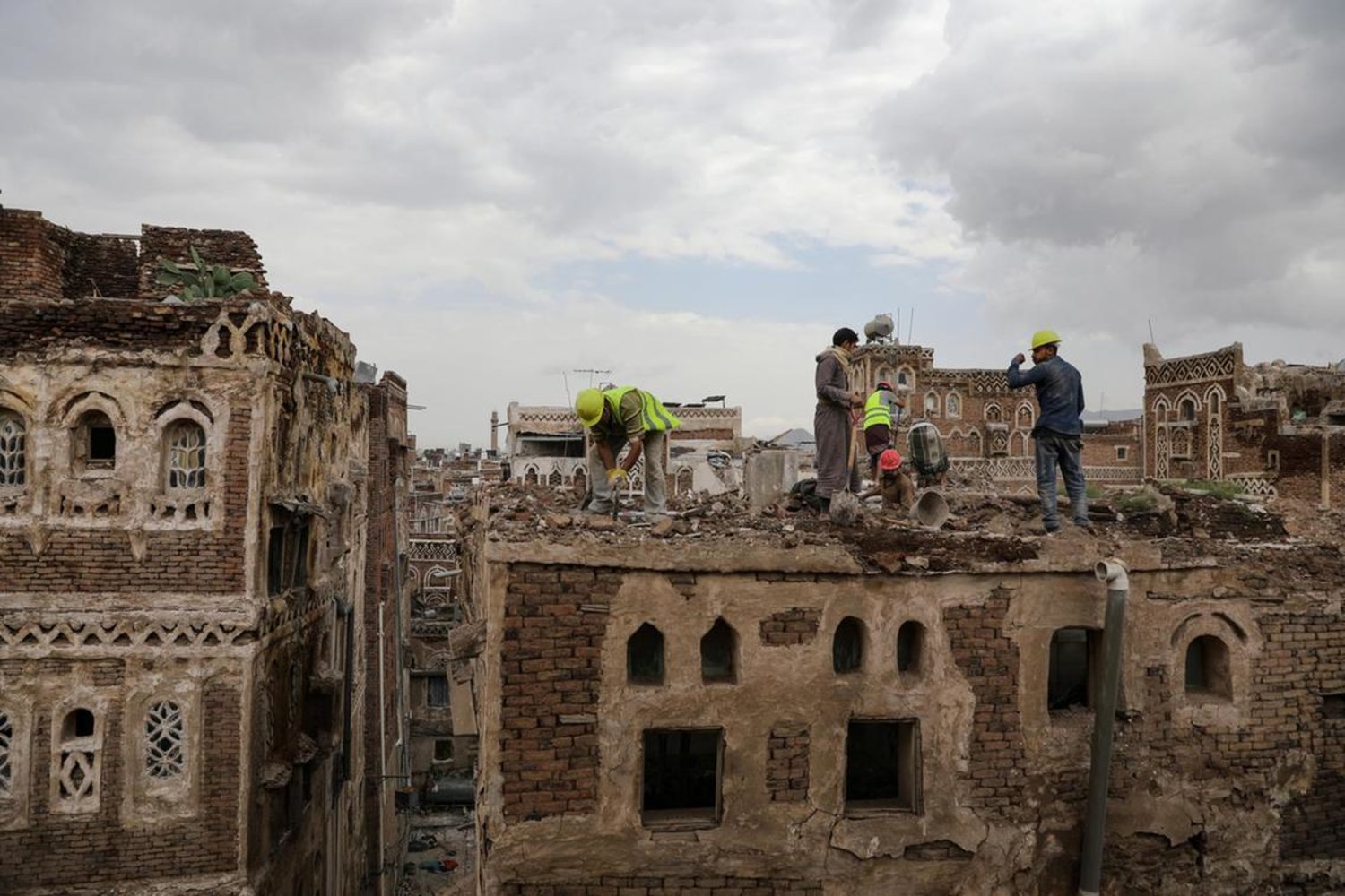 Workers clear rubble from a building damaged by rain in the Old City of Yemen's capital Sanaa on August 9, 2020. Reuters