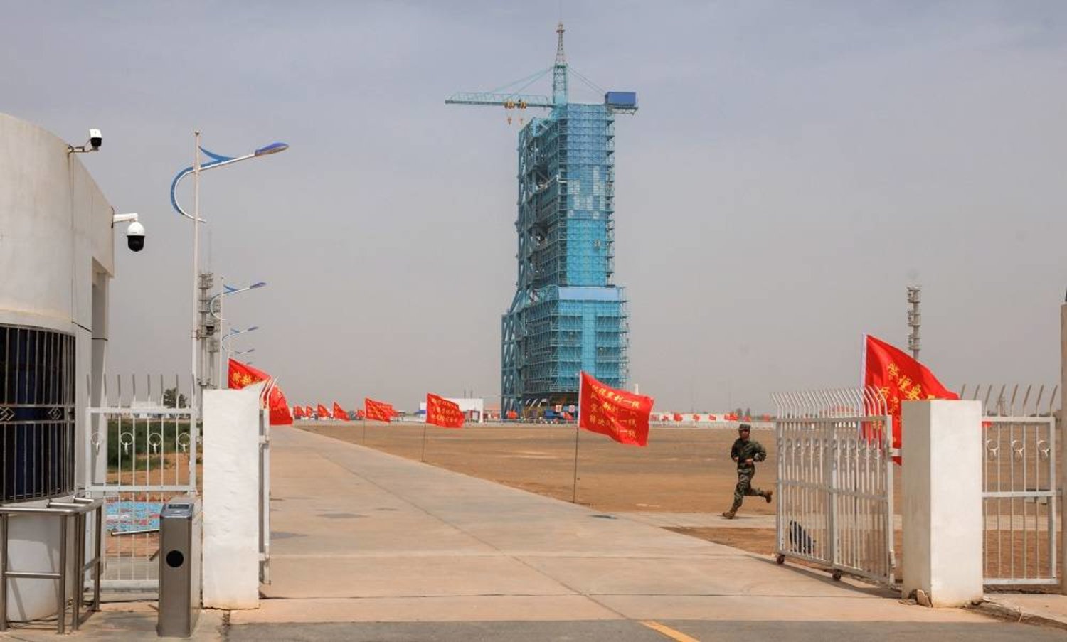 A member of People's Liberation Army (PLA) runs on the site of Shenzhou-16 manned space flight mission on the eve of launching in Jiuquan, Gansu province, China, 29 May 2023. (EPA) 