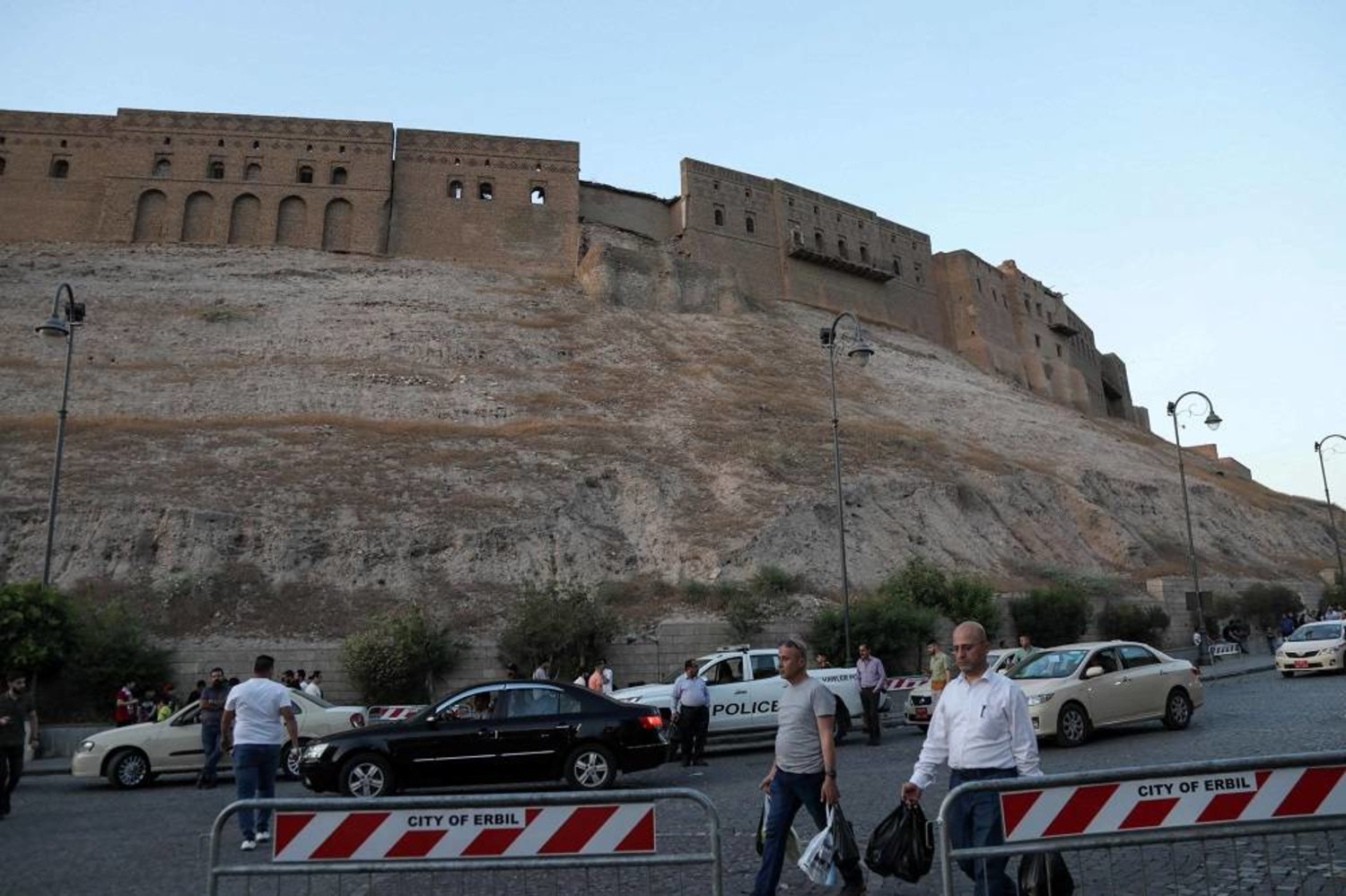 In this picture taken on May 16, 2023, people walk past the citadel of Erbil, the capital of the autonomous Kurdish region of northern Iraq. (AFP) 
