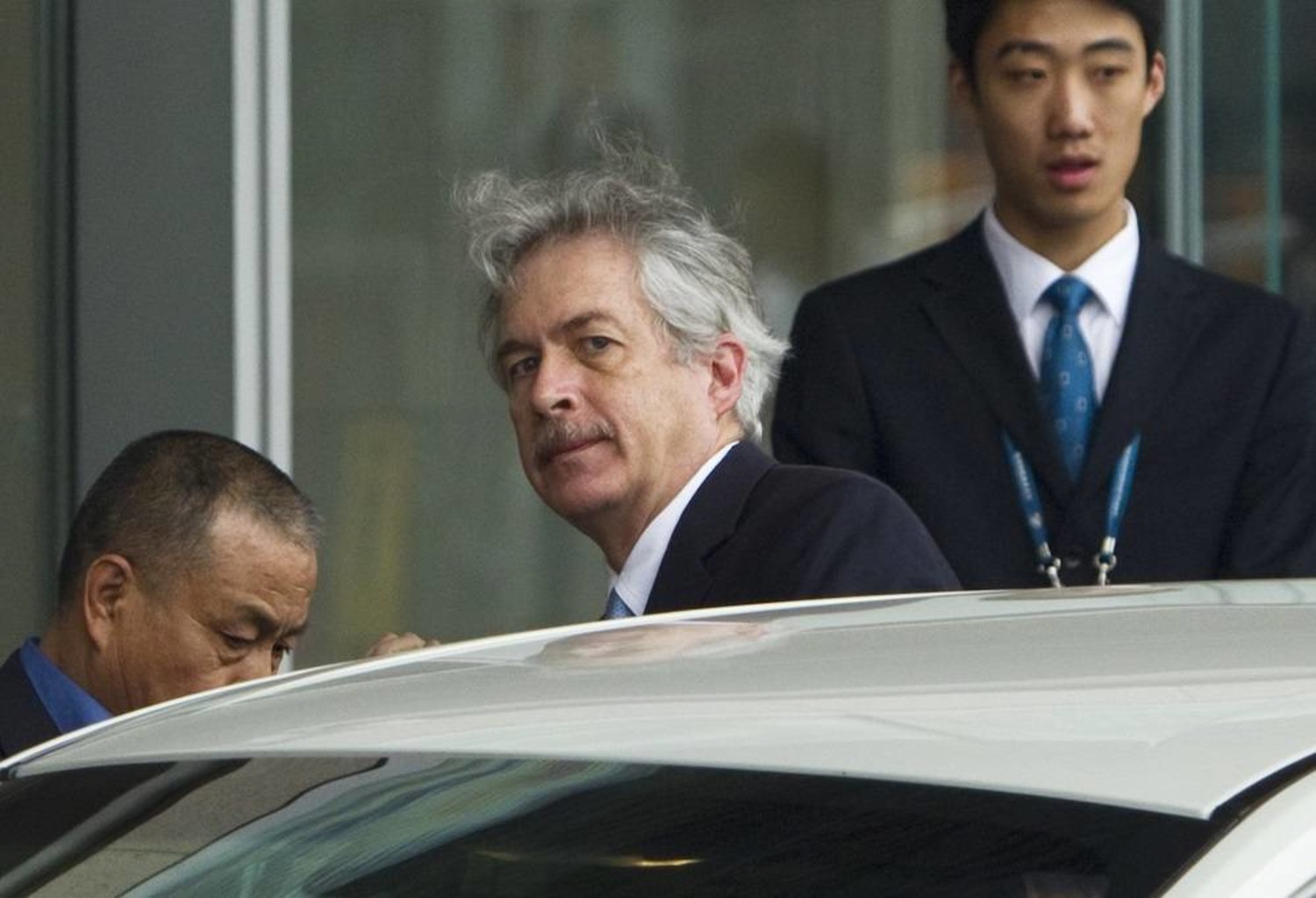 William Burns, center, enters a car after arriving at Capital International Airport in Beijing, May 1, 2012. (AP) 