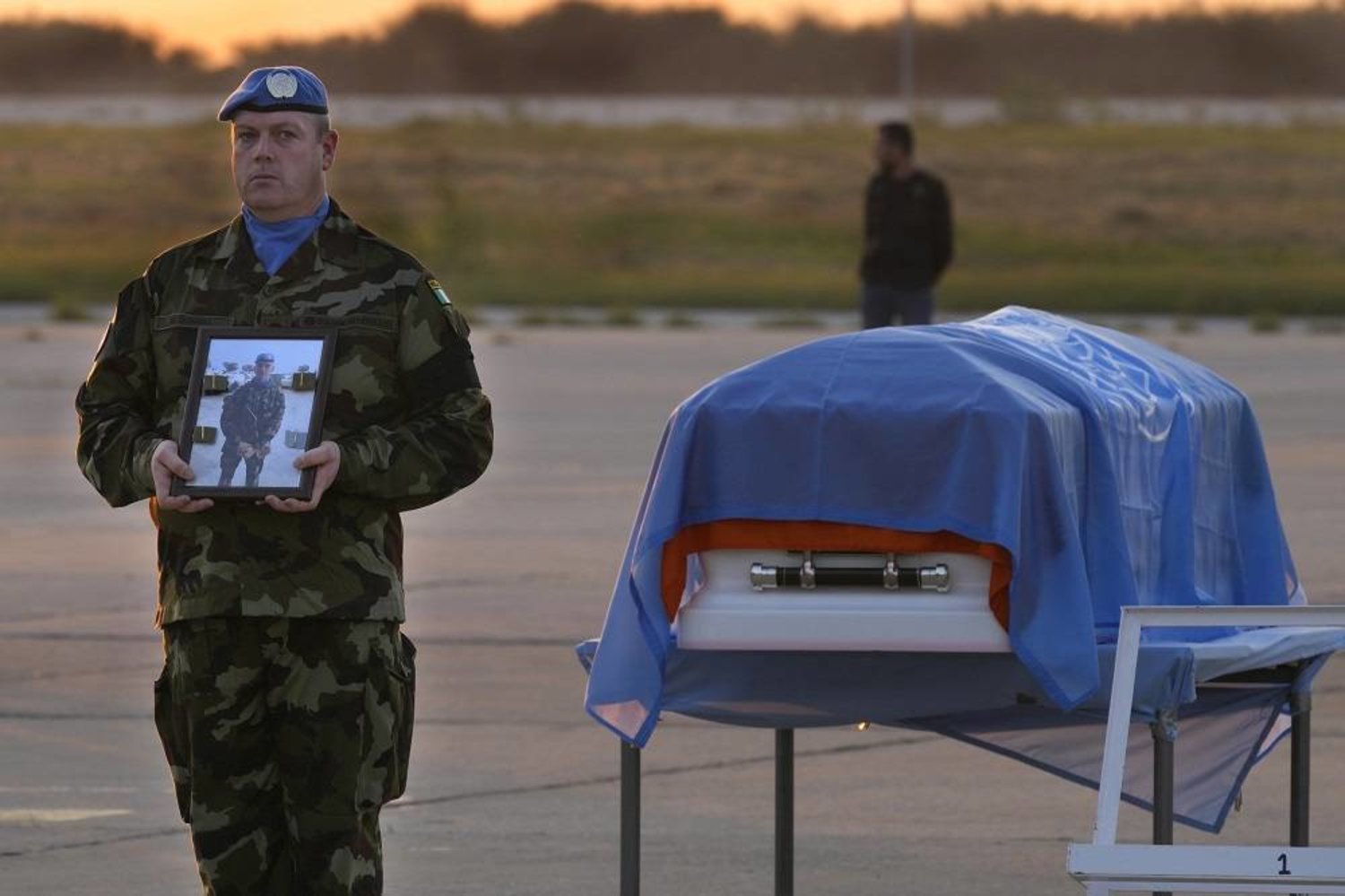 An Irish UN peacekeeper stands next to the coffin of his comrade Pvt. Sean Rooney, who was killed during a confrontation with residents near the southern town of Al-Aqbiya on Wednesday night, during a memorial service, at Beirut airport, Sunday, Dec. 18, 2022. (AP) 