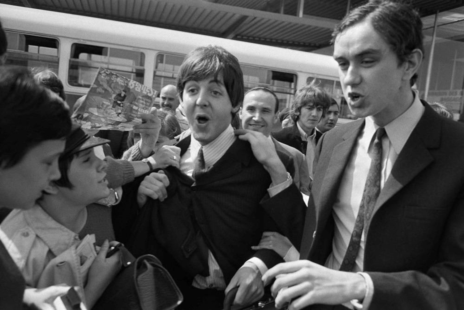 Fans surround Beatles Paul McCartney (C) and George Harrison (2R) upon their arrival at Orly airport on June 20, 1965, before their concert at the Palais des Sports the same evening. (AFP) 