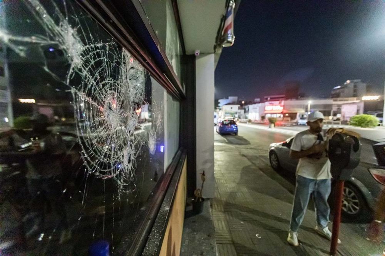 02 September 2023, Cyprus, Limassol: The store window is shattered as protesters attack a hair salon belonging to a migrant. (dpa)