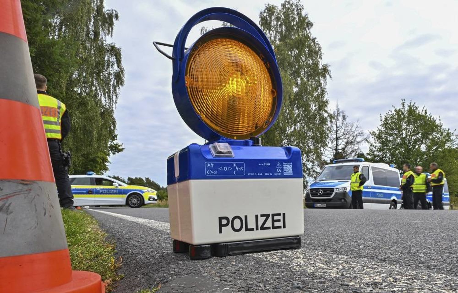 A warning signal stands on the road during a police check against smuggling of migrants, in Roggosen, Germany, Monday, Sept. 25, 2023. (dpa via AP)