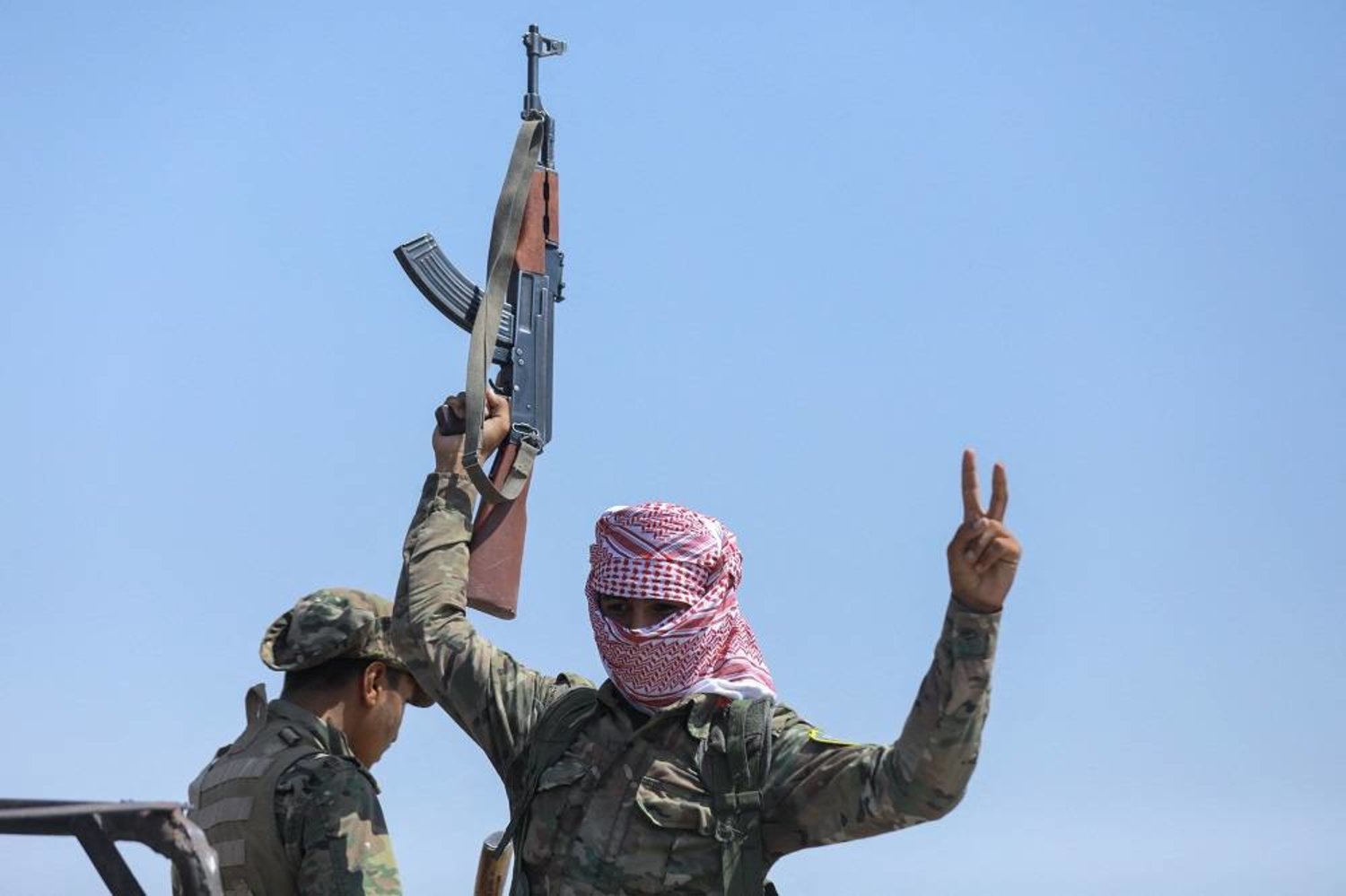 Fighters of the Syrian Democratic Forces (SDF) gesture as they move from Deir Ezzor to the Dheiban front line in eastern Syria on September 4, 2023, during a guided media tour organized by the SDF. (AFP)