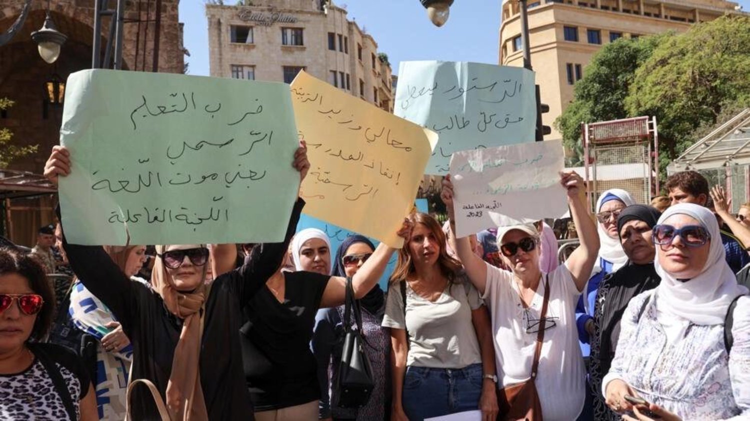 School teachers lift placards during a sit-in outside Lebanon's parliament protesting poor pay at public schools. ANWAR AMRO / AFP
