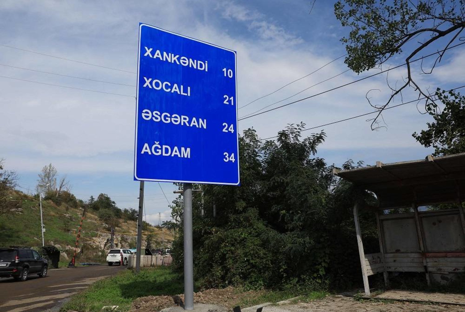 This photograph taken on October 2, 2023 in Stepanakert shows a new road sign, written in Azerbaijani, displaying the Azerbaijani names for the towns Khankendi, Khojaly, Asgaran and Aghdam in the newly controlled Azeri region of Nagorno-Karabakh, during an Azeri government organized media trip. (AFP)