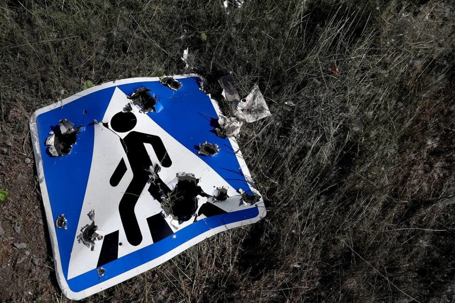 A road sign damaged by cluster munition is seen following a military strike, amid Russia's attack on Ukraine, on the outskirts of Kharkiv, Ukraine June 10, 2022. (Reuters)
