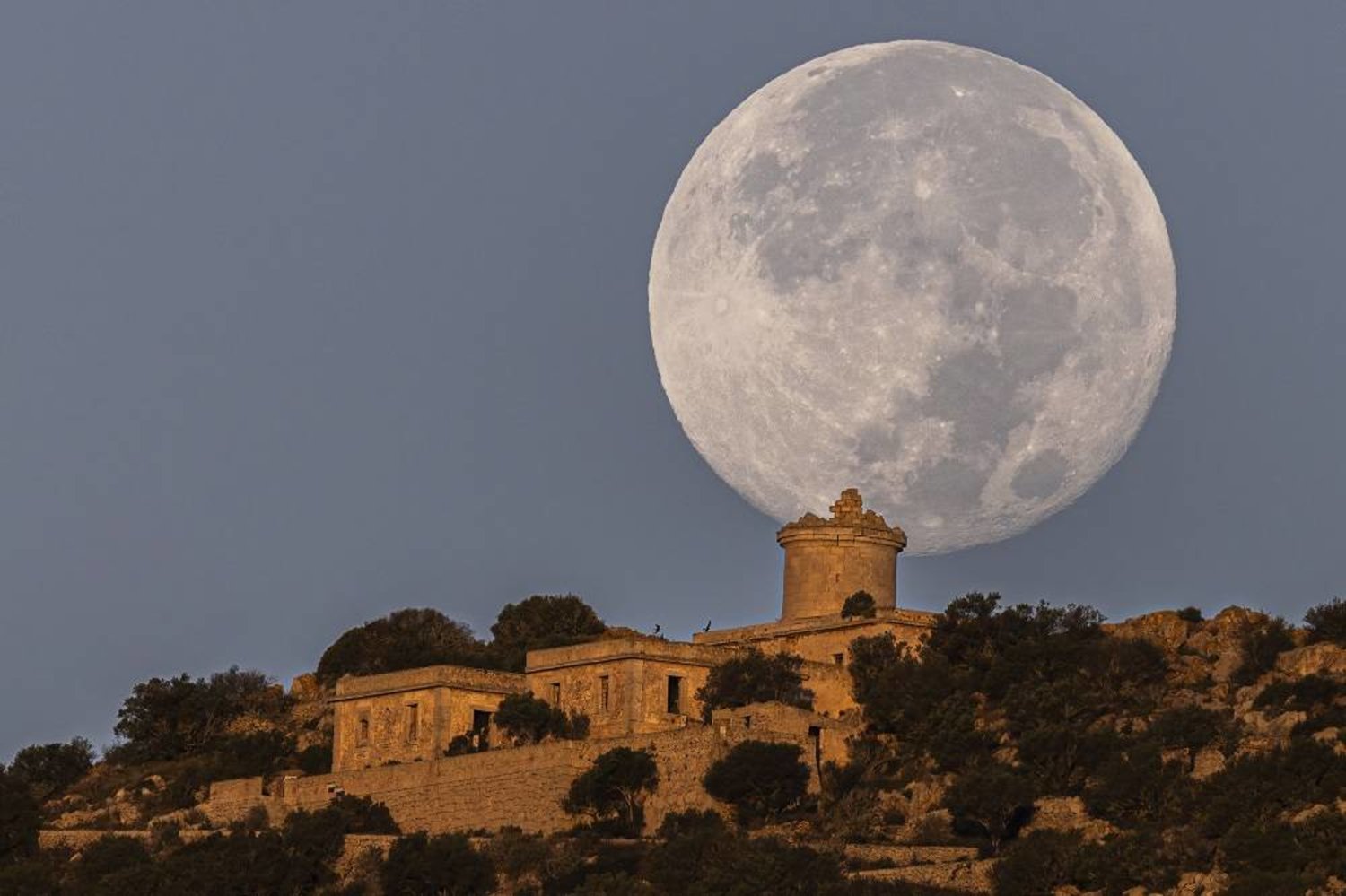 View of the last supermoon of the year, known as Harvest moon, from the village of Sant Elm, Majorca island, eastern Spain, early 30 September 2023. (EPA)