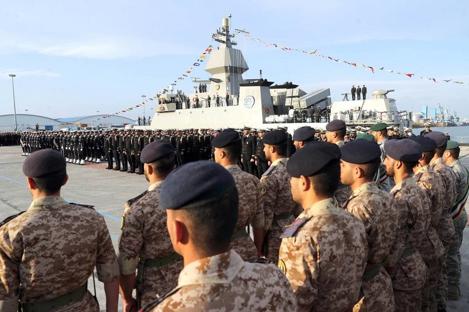 A handout photo made available by the Iranian army office shows Iranian Navy soldiers next to Iran's new warship “Deylaman” during an inauguration ceremony at the port of Bandar Anzali on the Caspian Sea, Iran, 27 November 2023. (EPA/Iranian army office/Handout) 