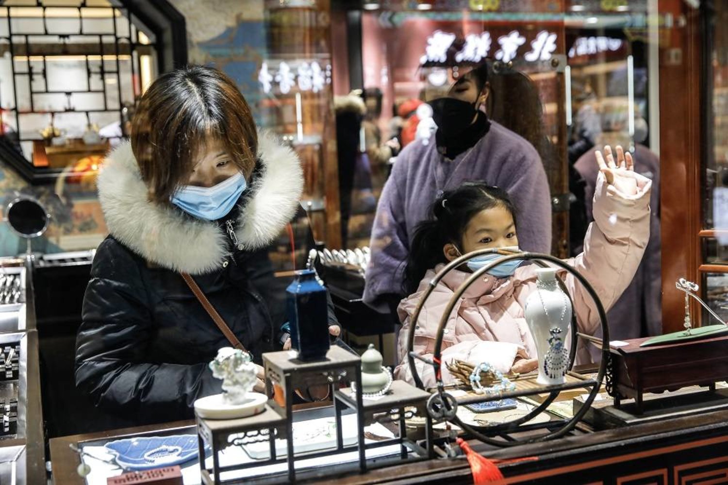 Tourists browse inside a souvenir shop at the Nanluoguxiang tourism area in Beijing, China, 25 November 2023. (EPA)