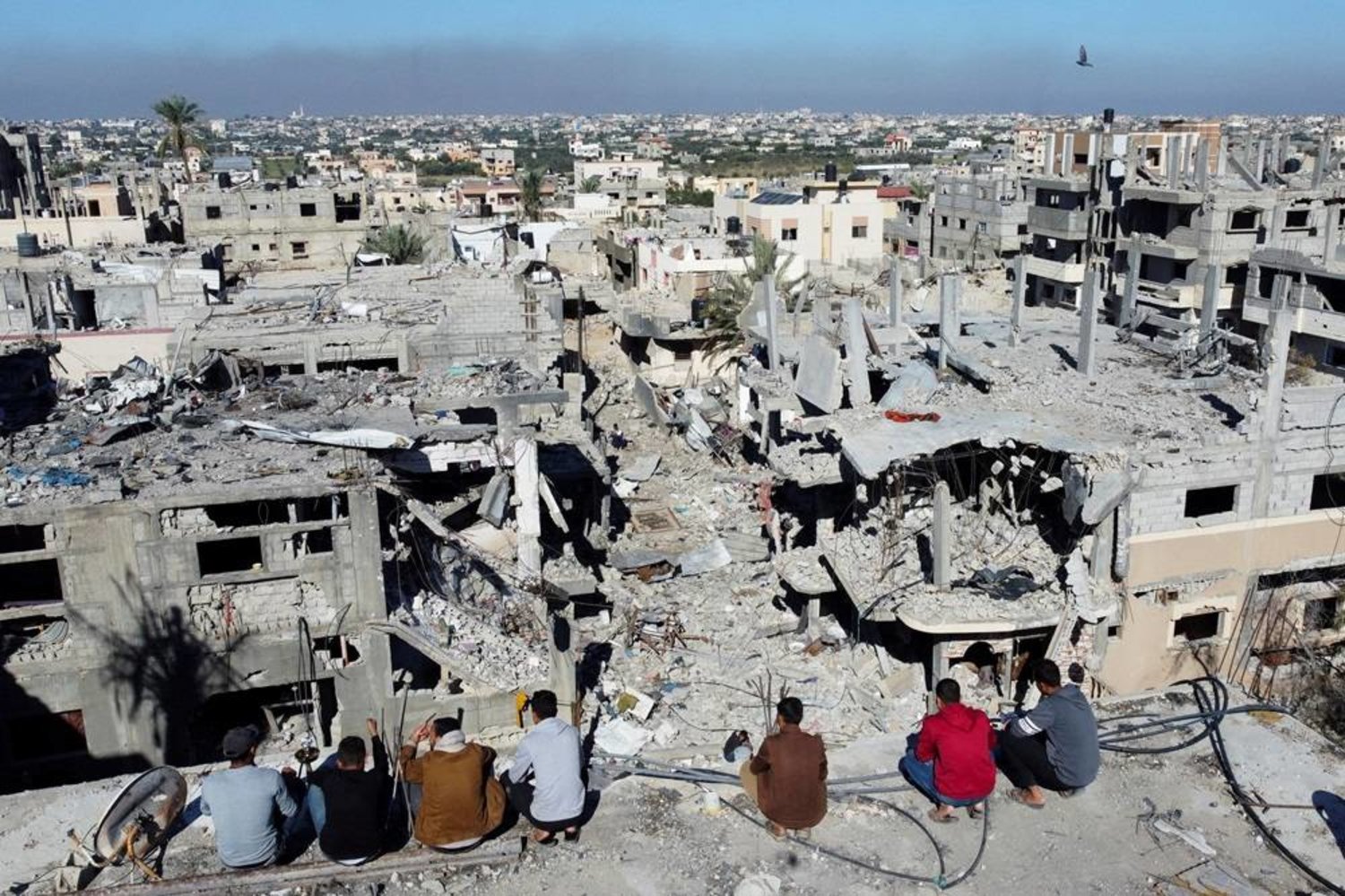 Palestinians look at the houses destroyed in Israeli strikes during the conflict, amid the temporary truce between Israel and the Palestinian group Hamas, at Khan Younis refugee camp, in the southern Gaza Strip, November 29, 2023. (Reuters)