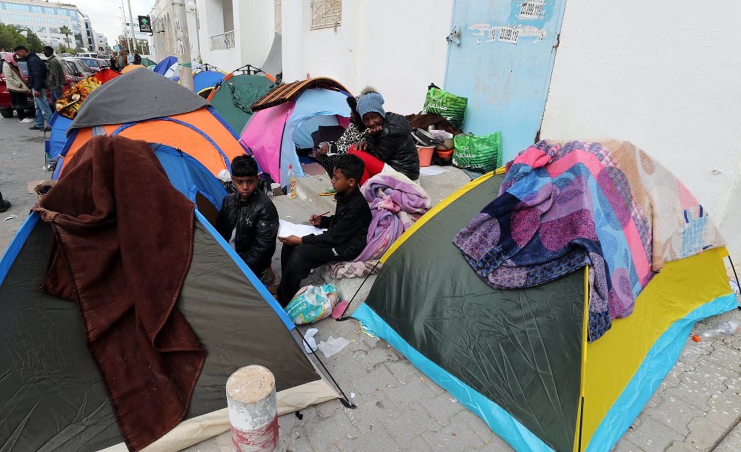 Sub-Saharan African migrants camp outside the headquarters of the International Organization for Migration (IOM) to demand their evacuation to their country of origin in Tunis, Tunisia, 22 March 2023. (EPA)