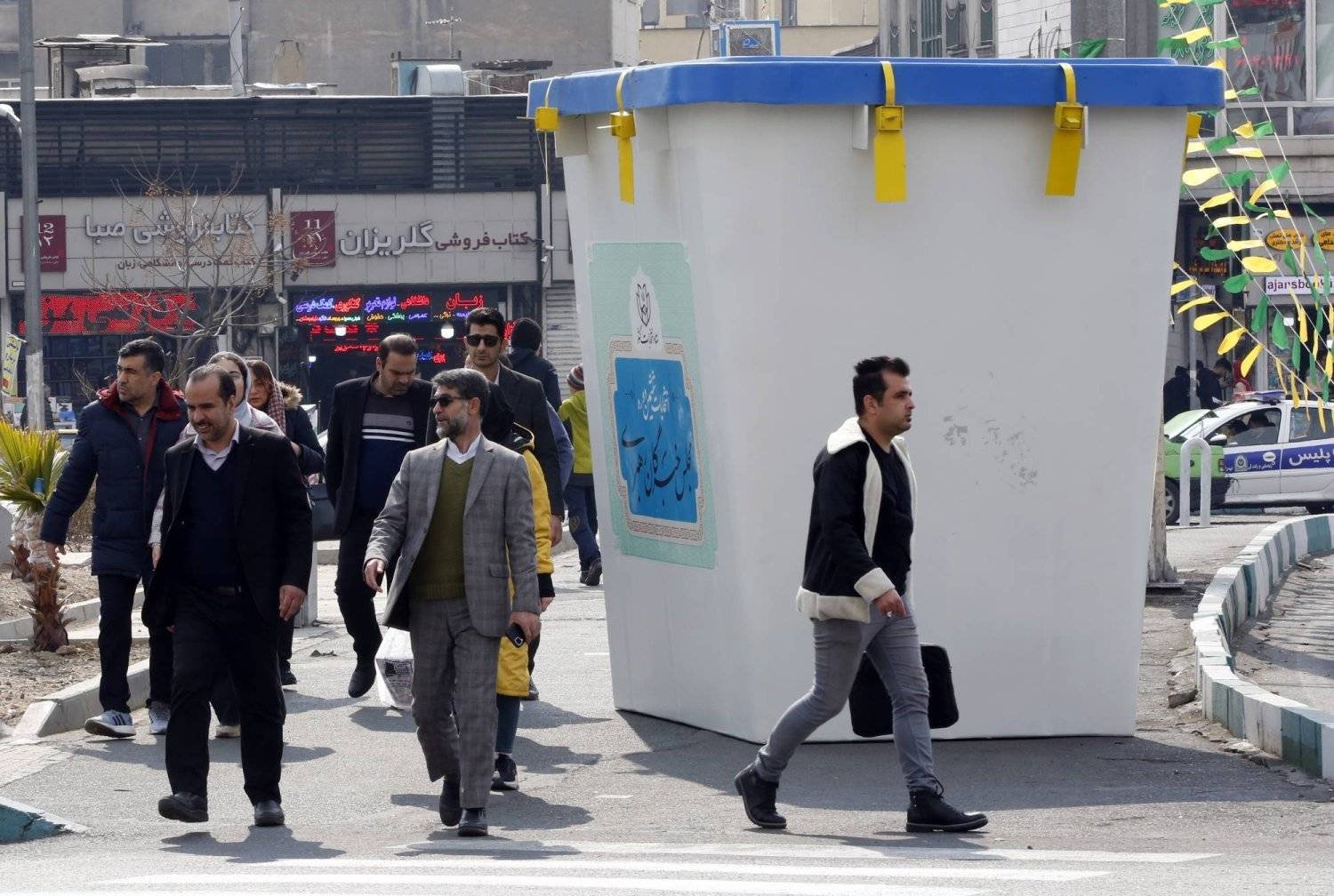 Iranians walk next to a symbol of the election ballot box during the first day of Iran's parliamentary election campaigns in a street in Tehran, Iran, 22 February 2024. (EPA)