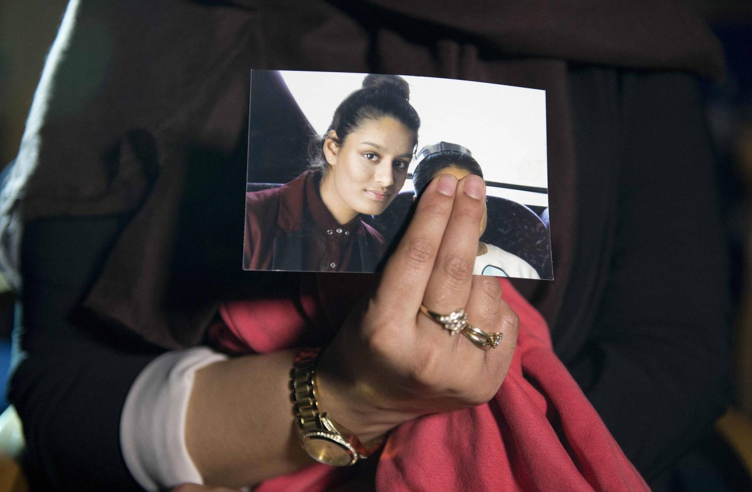 (FILES) Renu, eldest sister of missing British girl Shamima Begum, holds a picture of her sister while being interviewed by the media in central London, on February 22, 2015. (Photo by LAURA LEAN / POOL / AFP)