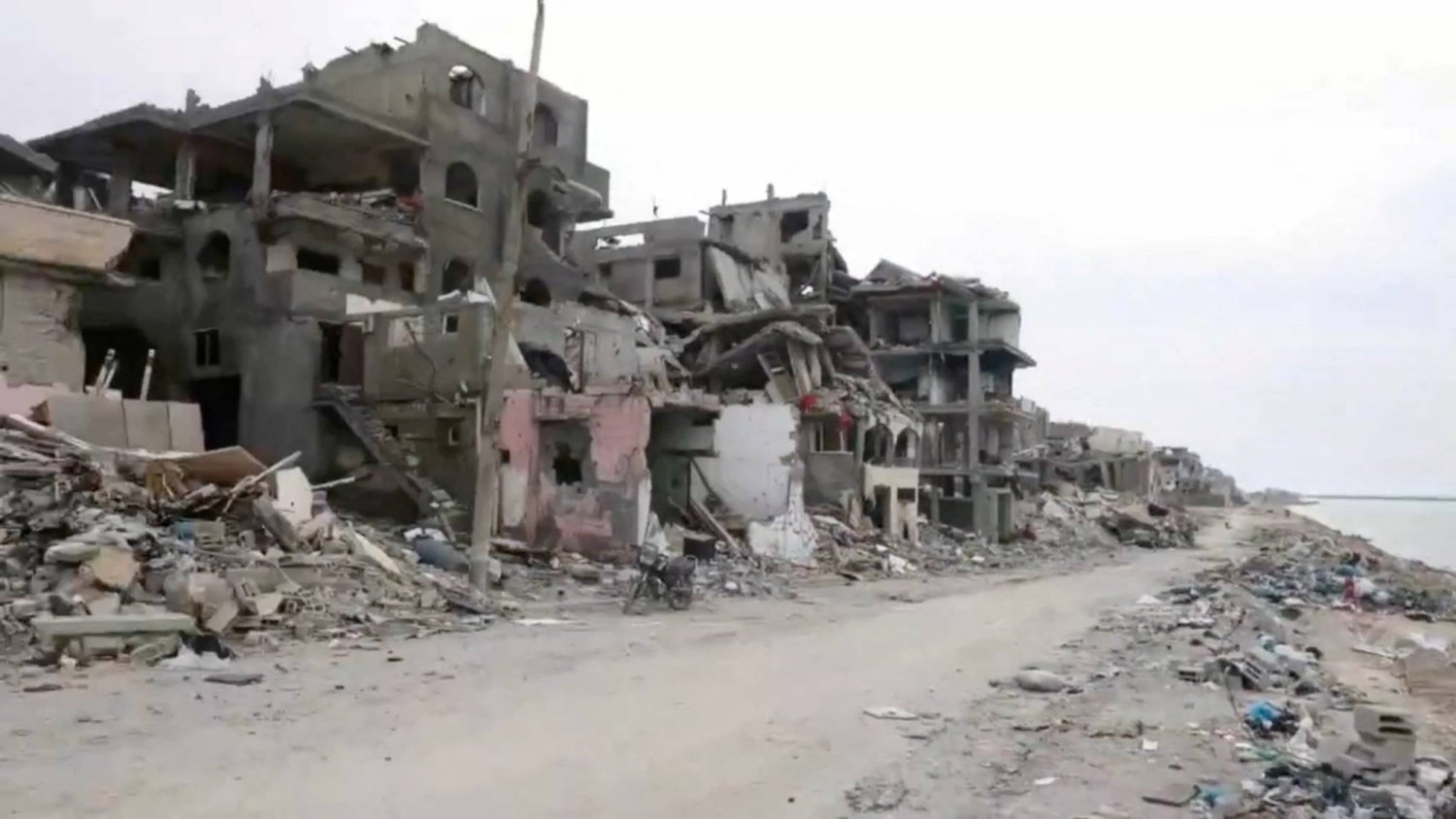 Destroyed buildings stand along a rubble-strewn street, amid the ongoing conflict between Israel and the Palestinian group Hamas, in Gaza, in this still image taken from video released February 15, 2024. UNRWA/Handout via REUTERS  