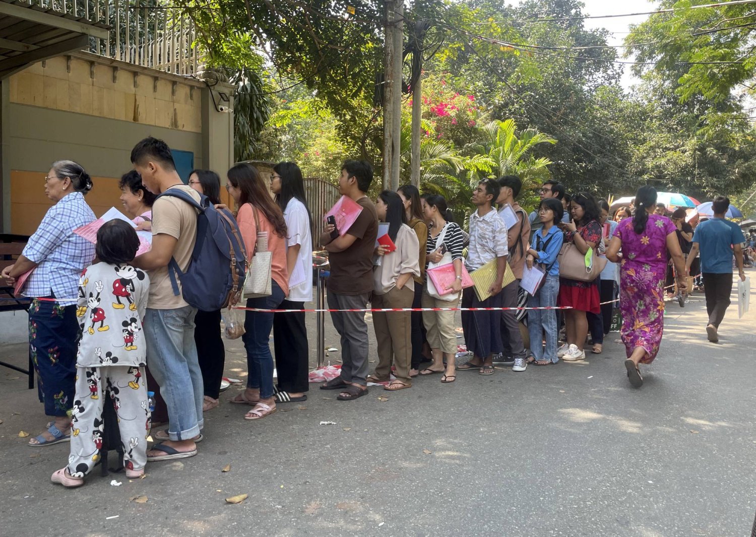 People queue to receive a token to apply for a visa outside the Royal Thai embassy in Yangon, Myanmar, 16 February 2024. EPA/STRINGER