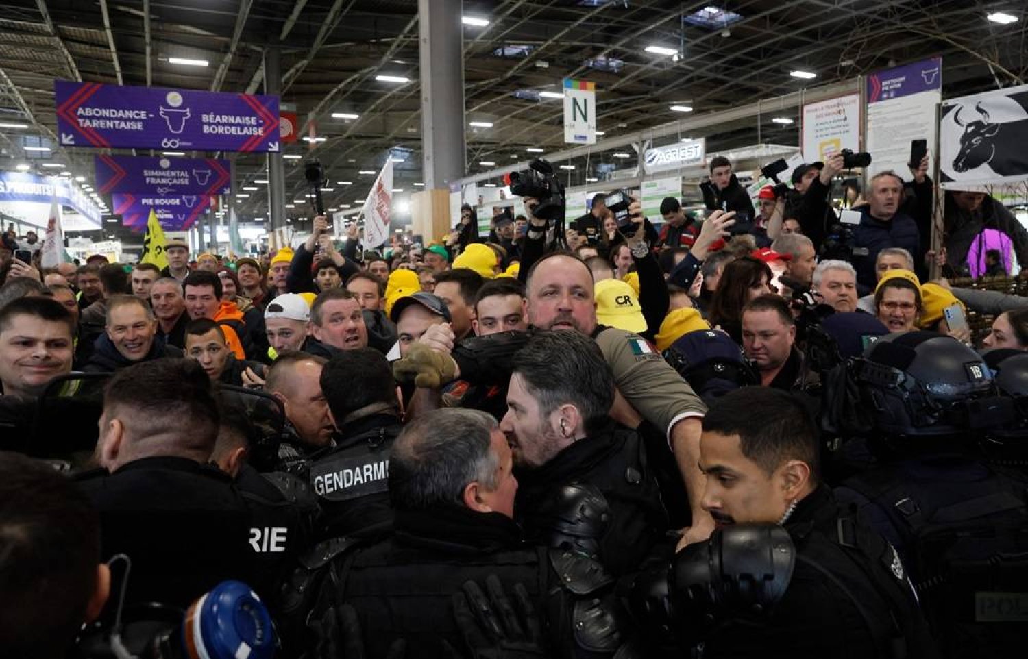 French farmers scuffle with gendarmes (bottom) during a farmers' protest at the Porte Versailles exhibition center, prior to the opening of the 60th International Agriculture Fair (Salon de l'Agriculture), in Paris, on February 24, 2024. (AFP)
