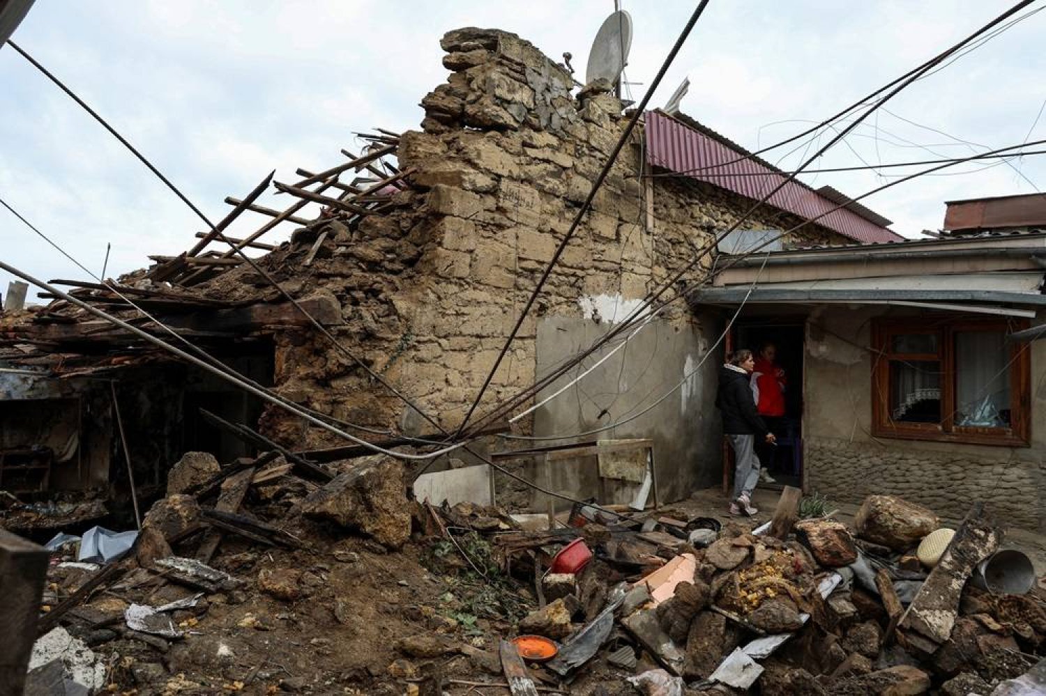  Local women stand next to their house heavily damaged by a Russian drone strike, amid Russia's attack on Ukraine, in Odesa, February 24, 2024. (Reuters)