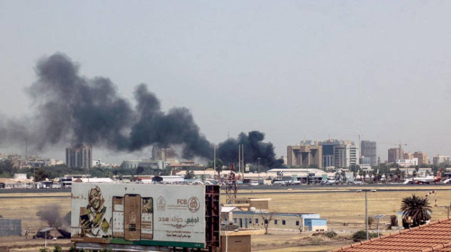 Smoke rises above buildings in the vicinity of Khartoum Airport. (AFP)