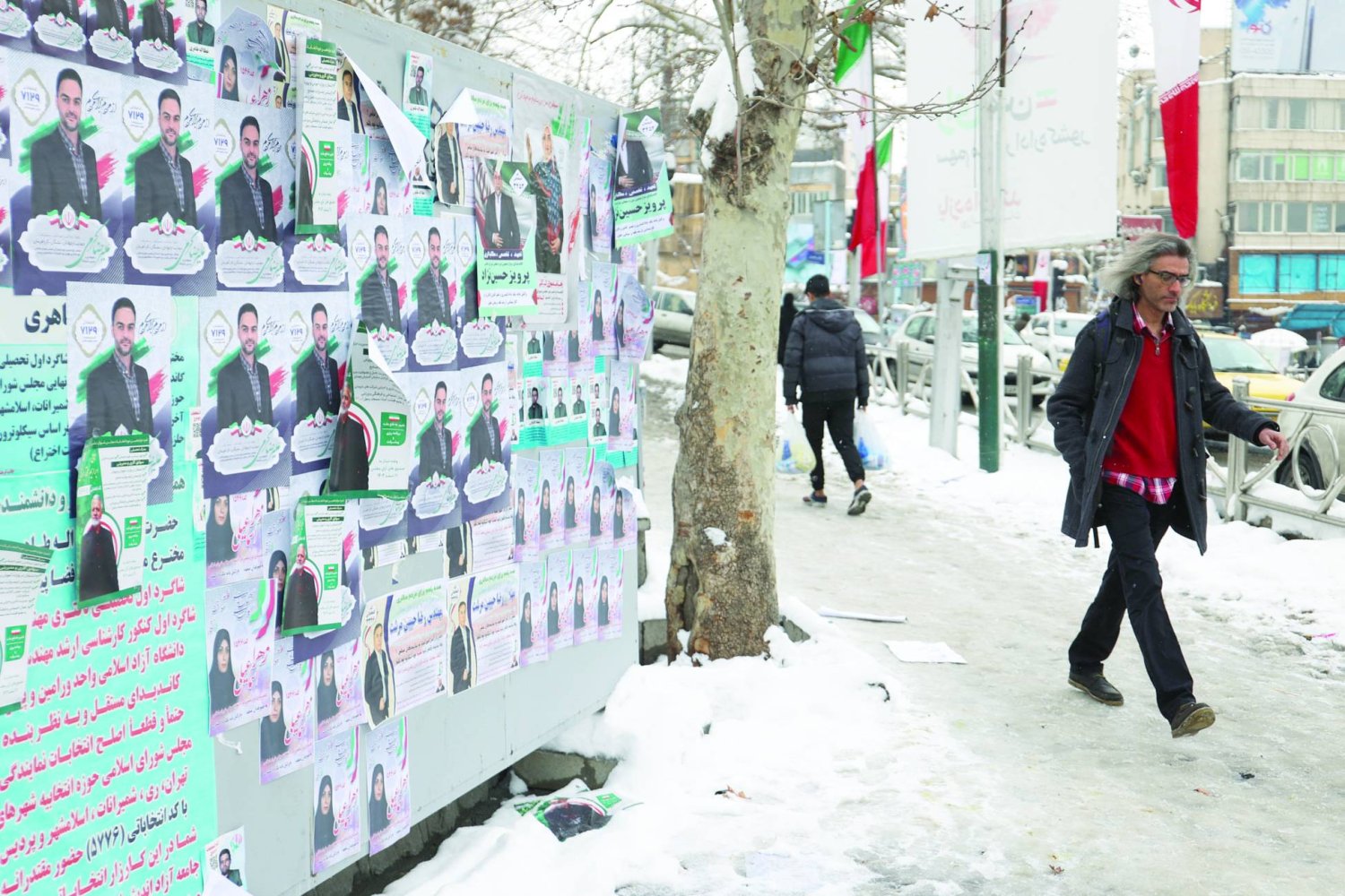 People walk past campaign posters for the parliamentary election during the last day of election campaigning in Tehran, Iran, February 28, 2024. Majid Asgaripour/WANA (West Asia News Agency) via REUTERS 