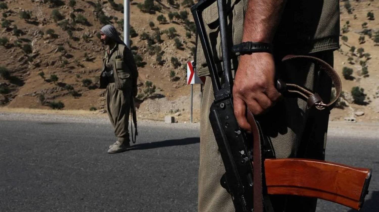 A member of the PKK carries an automatic rifle on a road in Iraq's Qandil Mountains in 2018. (AFP)
