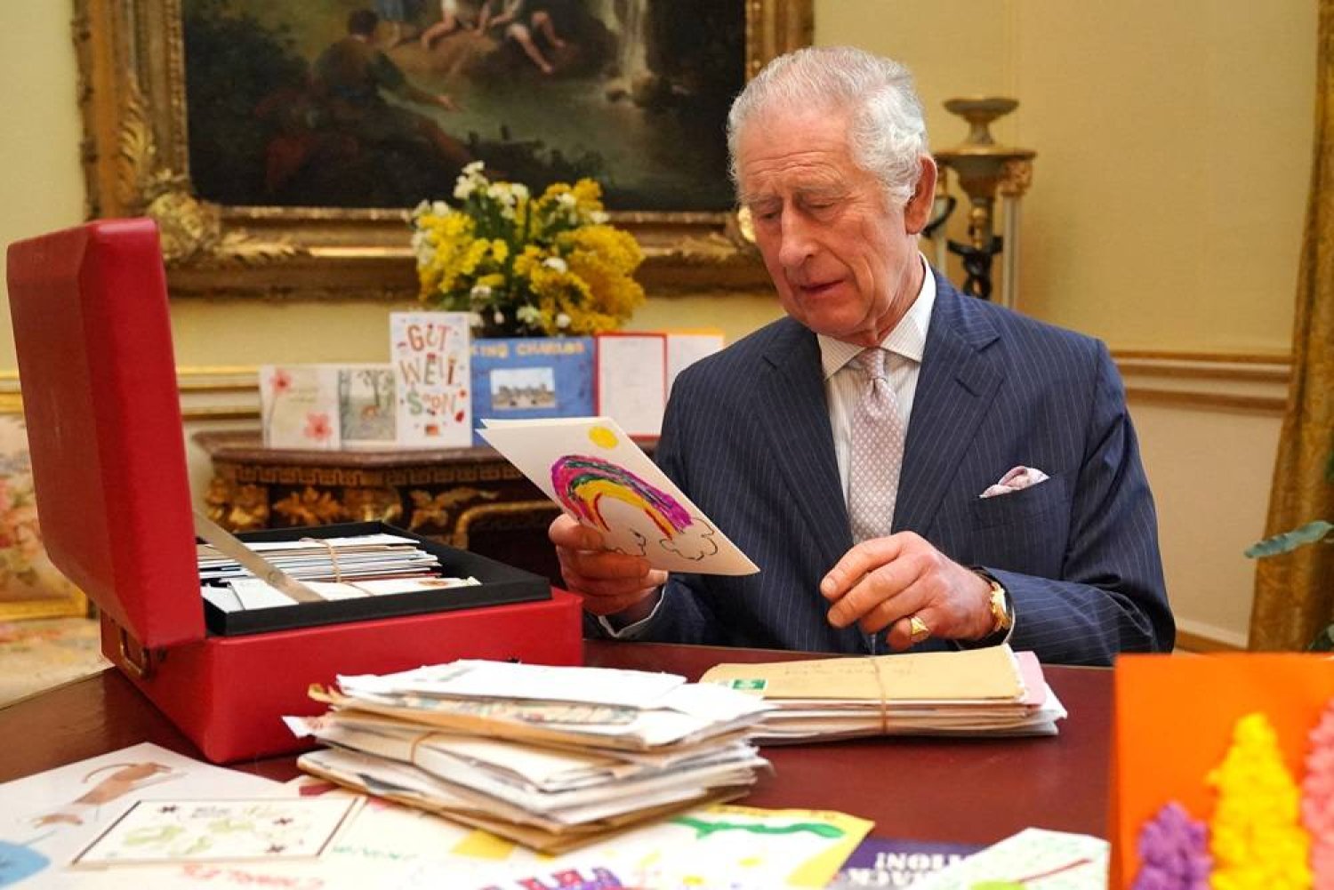 Britain's King Charles reads cards and messages, sent by well-wishers following his cancer diagnosis, in the 18th Century Room of the Belgian Suite in Buckingham Palace, London, Britain, February 21, 2024. (Reuters)