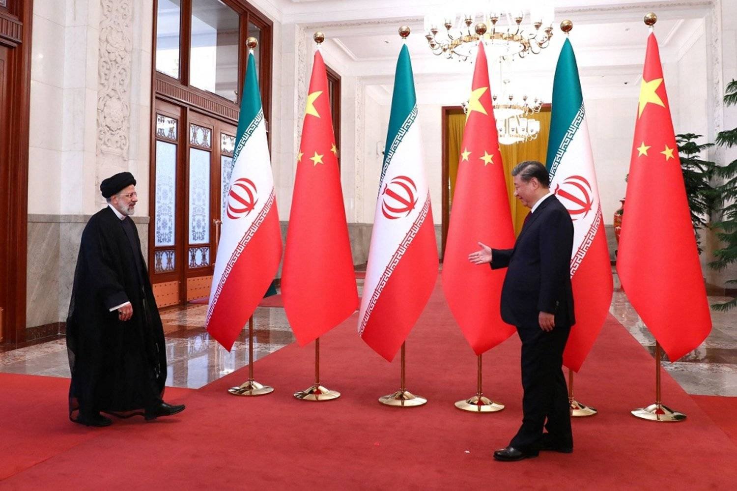 This handout picture provided by the Iranian presidency shows Chinese President Xi Jinping welcoming Iranian President Ebrahim Raisi (L) during his visit in Beijing on February 14, 2023. (Iranian Presidency / AFP)

