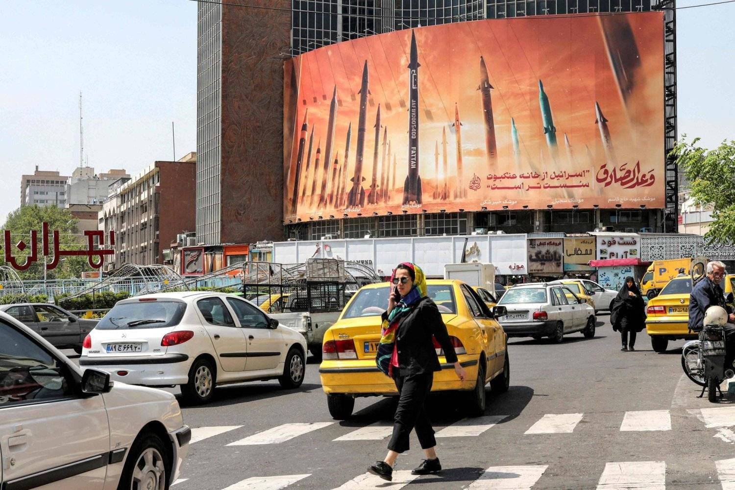 A billboard depicting Iranian ballistic missiles and reading “The True Promise”, in Vali Asr Square in central Tehran (AFP)
