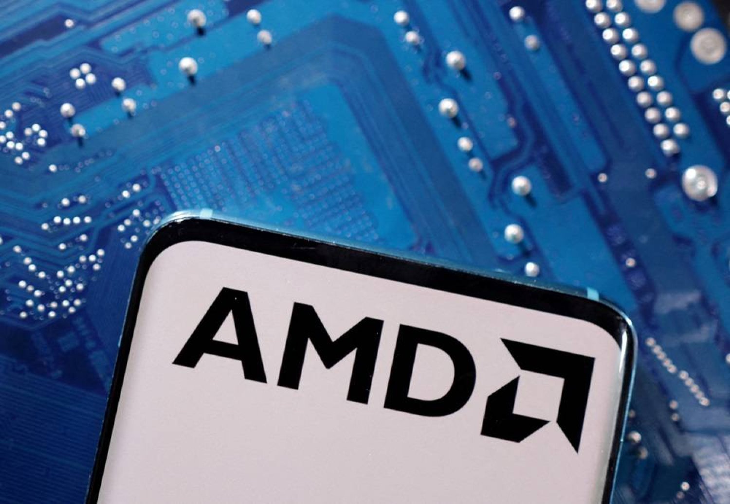 A smartphone with a displayed AMD logo is placed on a computer motherboard in this illustration taken March 6, 2023. (Reuters)