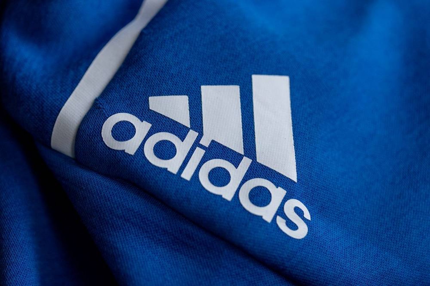 08 March 2022, Bavaria, Herzogenaurach: The logo of the sporting goods manufacturer Adidas on a blue jacket. (dpa)