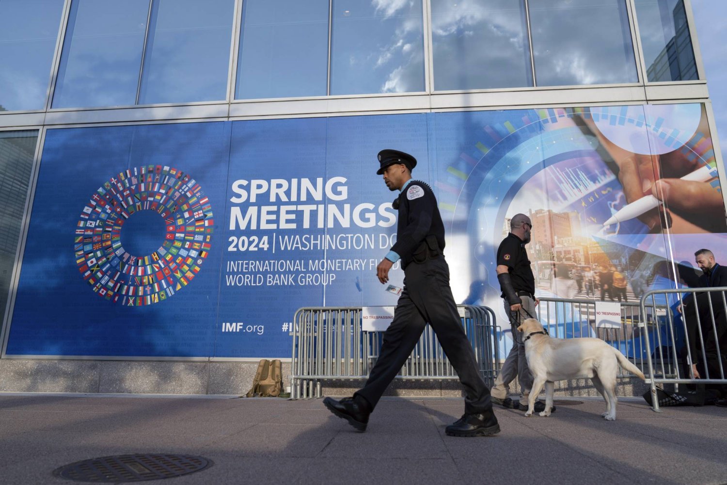 An International Monetary Fund police officer walks by an IMF banner, during the World Bank/IMF Spring Meetings in Washington, Thursday, April 18, 2024. (AP Photo/Jose Luis Magana)