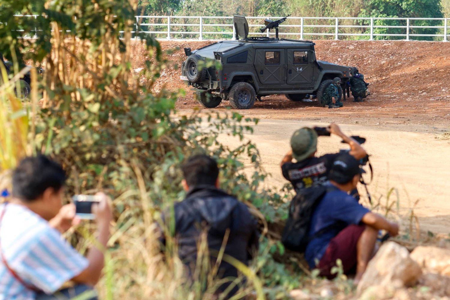 Thai soldiers and members of the media take cover near the 2nd Thailand-Myanmar Friendship Bridge during fighting on the Myanmar side between the Karen National Liberation Army (KNLA) and Myanmar's troops, which continues near the Thailand-Myanmar border, in Mae Sot, Tak Province,  Thailand, April 20, 2024. REUTERS/Soe Zeya Tun
