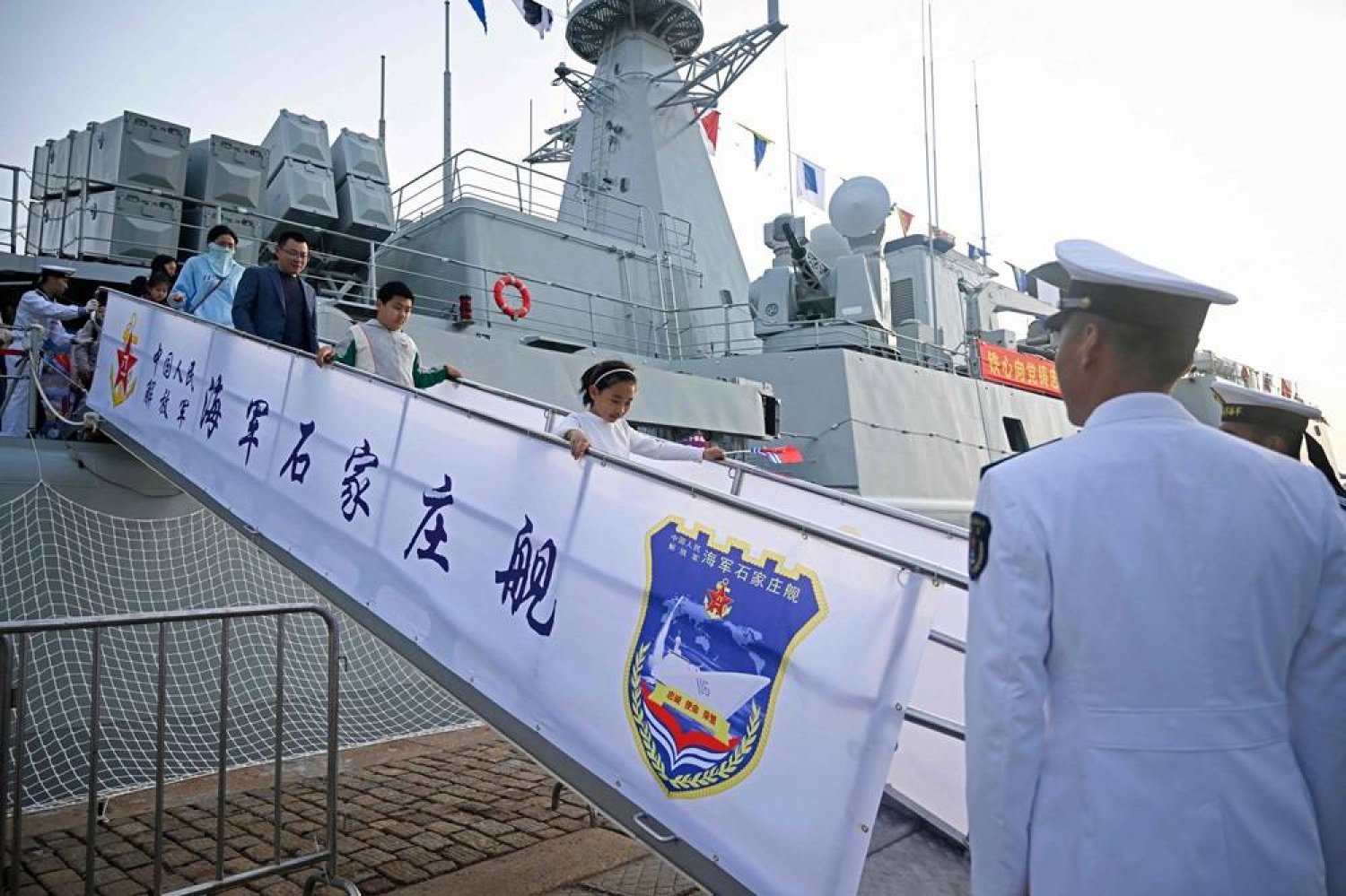  People step off gangway after their visiting Chinese Navy Shijianzhuang destroyer during a media tour organised by Chinese Navy at a port in Qingdao, China's Shandong province on April 20, 2024. (AFP) 