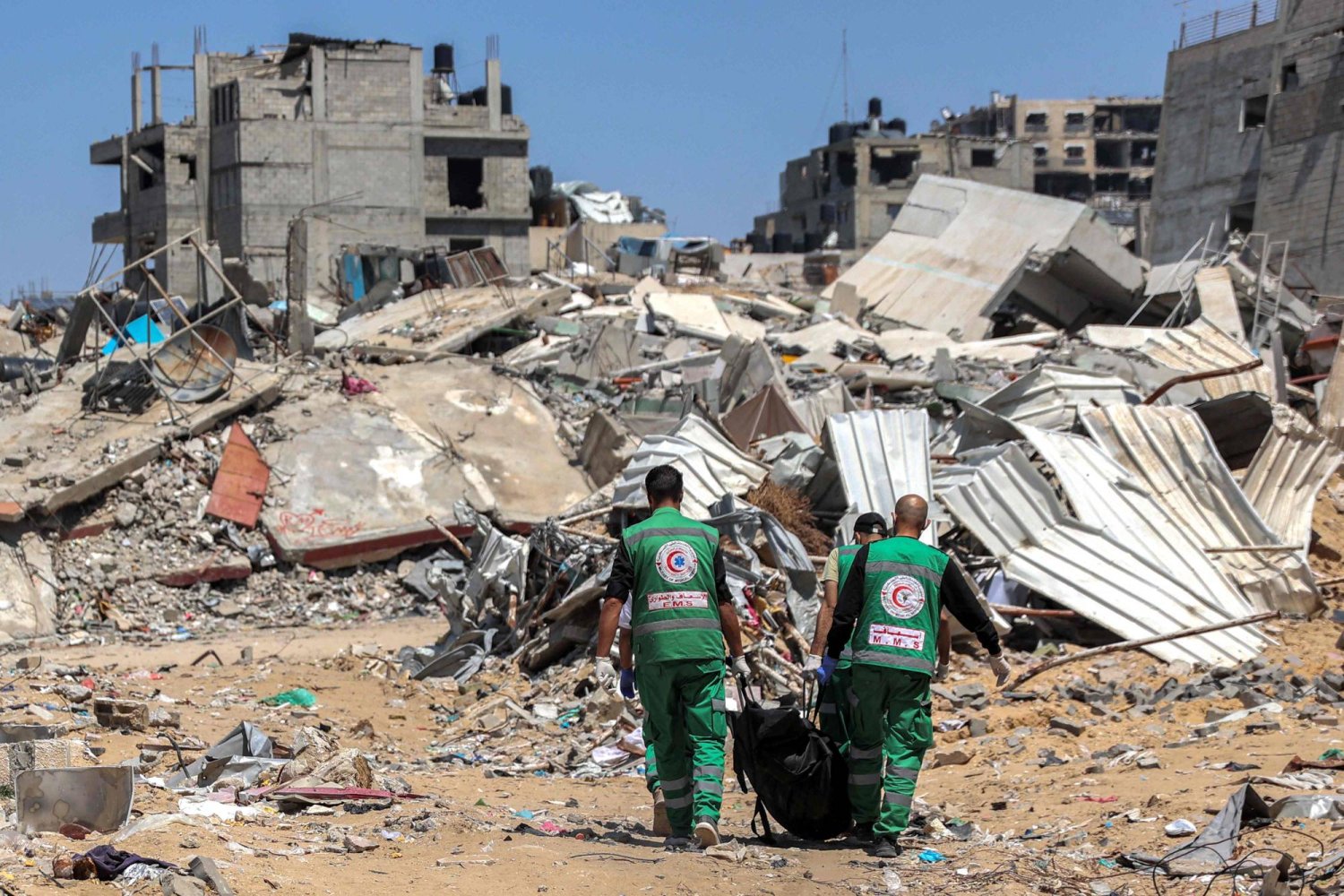 Palestinian paramedics carry away bodies of dead people uncovered in the vicinity of Al-Shifa Hospital in Gaza City on April 17, 2024 after the recent Israeli military operation there. (Photo by AFP)