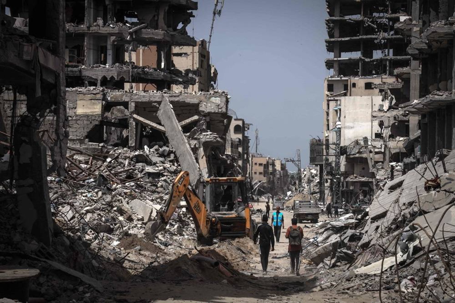  People walk on a road lined with destroyed buildings in Khan Younis in the southern Gaza Strip on April 23, 2024 amid the ongoing conflict between Israel and Hamas. (AFP) 