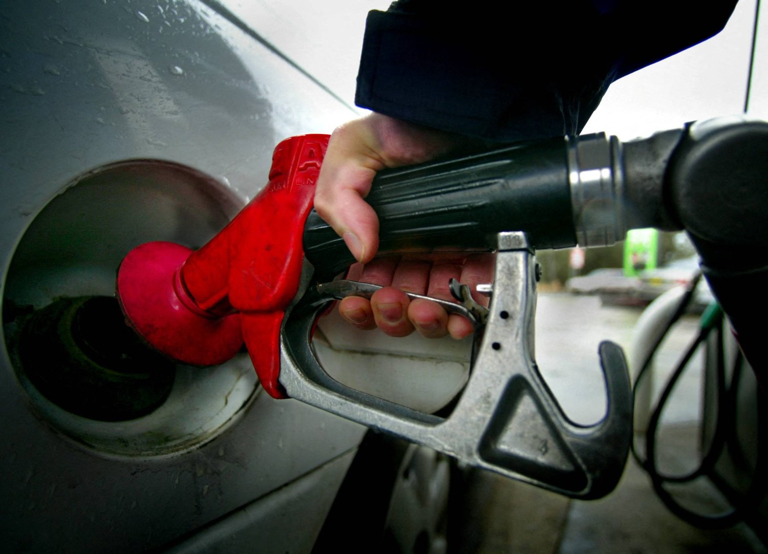 FILE PHOTO: A motorist fills a car with fuel at a petrol station in Sydney August 18, 2004. REUTERS
