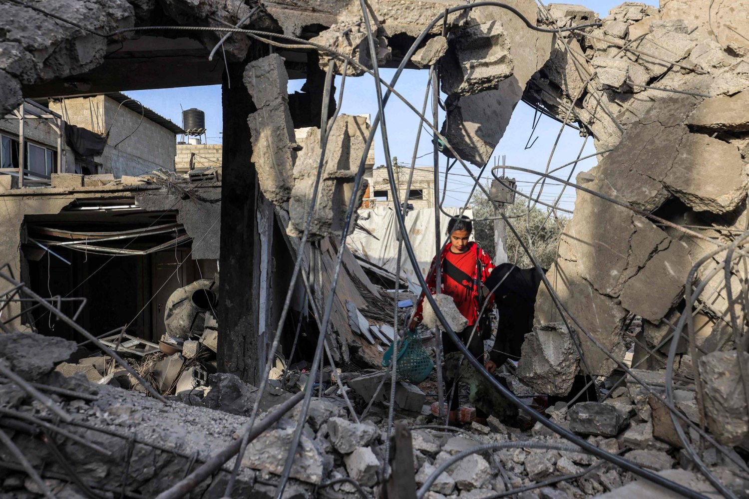 A woman and a girl search for items through the rubble of a collapsed building in Rafah in the southern Gaza Strip on April 24, 2024 following reported Israeli air strikes overnight. (Photo by MOHAMMED ABED / AFP)
